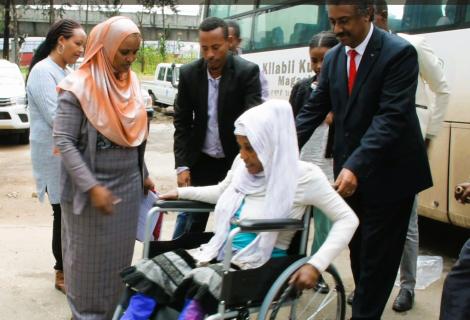 State Minister Dr. Abraha and ActionAid Representative Mr. Dechassa helping Abeba move the wheelchair
